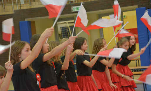 Uczniowie z flagami w narodowych kolorach
