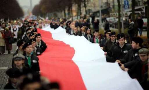 Harcerze trzymają flagę biało-czerwoną